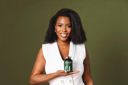 Kendria Strong, founder & owner of ROOTED REVIVall, showcasing plant-based hair care products.